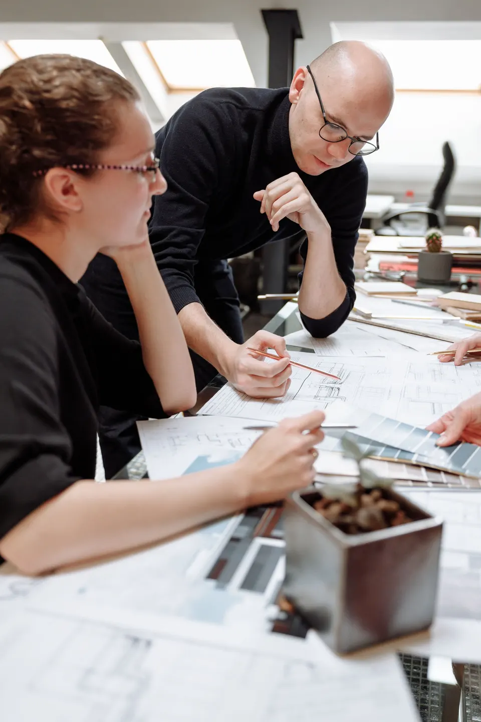Collega's kijken samen naar tekeningen op een tafel